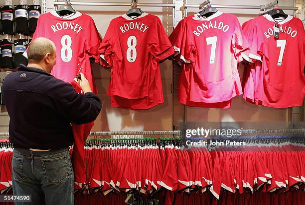 Fan looks at Ronaldo and Wayne Rooney replica shirts in the Megastore at Manchester United's Old Trafford stadium on Wednesday 13 October 2004 in...