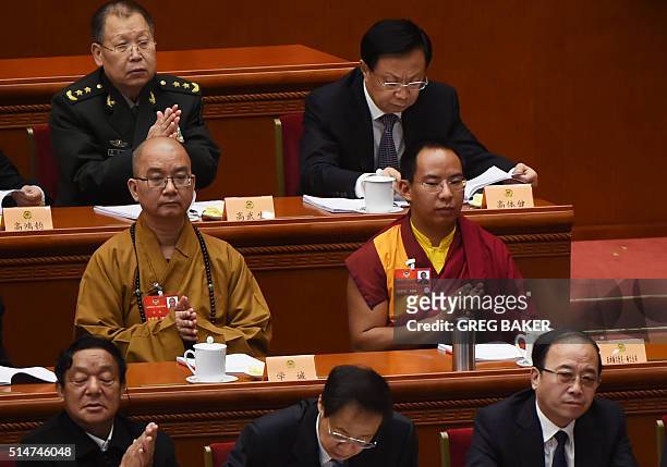The Chinese government-selected 11th Panchen Lama Gyaincain Norbu sits with other delegates during the third plenary session of the Chinese People's...