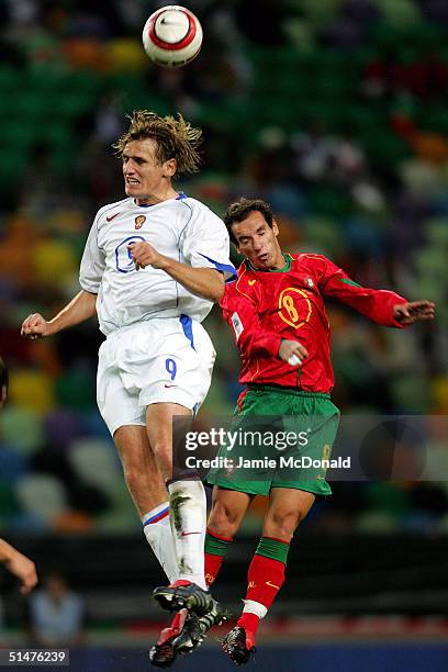 Petit of Portugal jumps with Dmitry Bulykin of Russia during the World Cup Group 3 match between Portugal and Russia on October 13, 2004 at the...