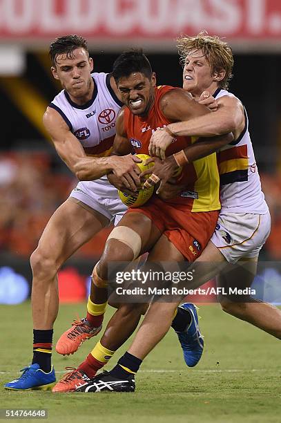 Aaron Hall of the Suns is tackled during the NAB Challenge AFL match between the Gold Coast Suns and the Adelaide Crows at Metricon Stadium on March...