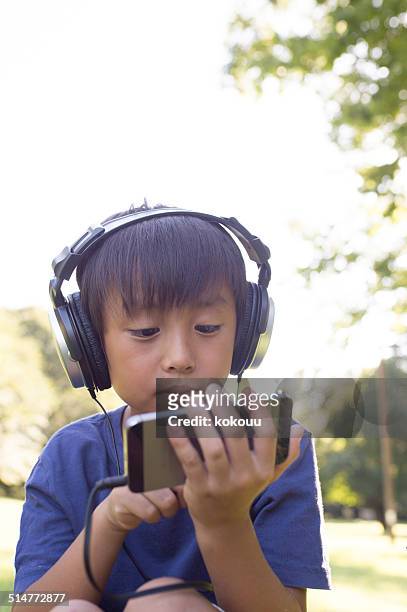 junge anhören von musik auf smartphone - 2014 asian games stock-fotos und bilder