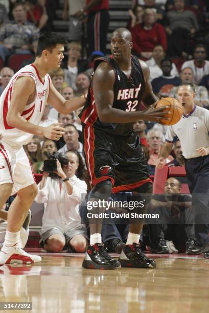 Shaquille O'Neal of the Miami Heat moves the ball against Yao Ming of the Houston Rockets during the preseason game at Toyota Center on October 10,...