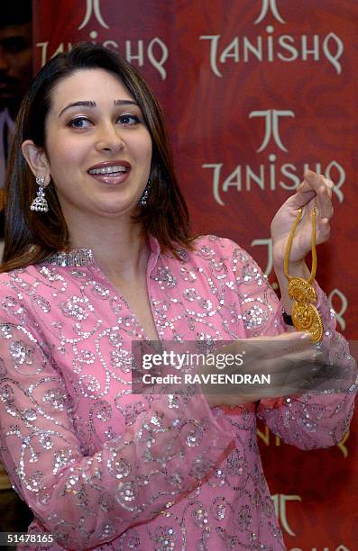Indian film actress Karisma Kapoor unveils a bracelet during a product launch by jewellery firm Tanishq in New Delhi, 14 October 2004. Tanishq has...