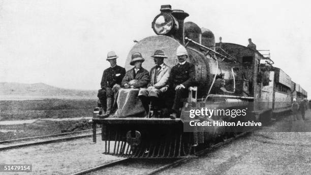 English statesman Joseph Chamberlain , travelling on the cow-catcher at the front of a train during a visit to Uganda in his capacity as Colonial...