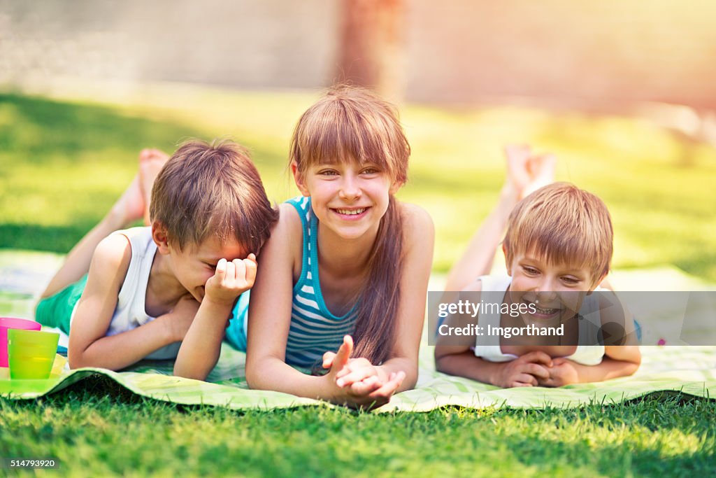 Enfant couché sur l'herbe en profitant de drôle de couverture de pique-nique de printemps.