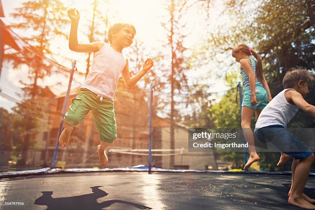 Kids jumping on garden trampoline