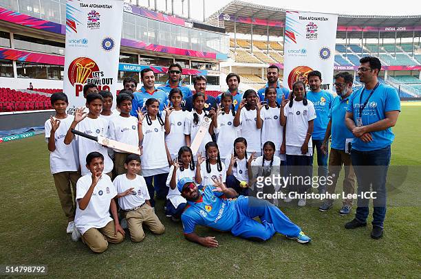 Mohammad Nabi, Shapoor Zadran, Asghar Stanikzai, Mohammad Shahzad and Dawlat Zadran of Afghanistan pose for the camera's with local kids during the...