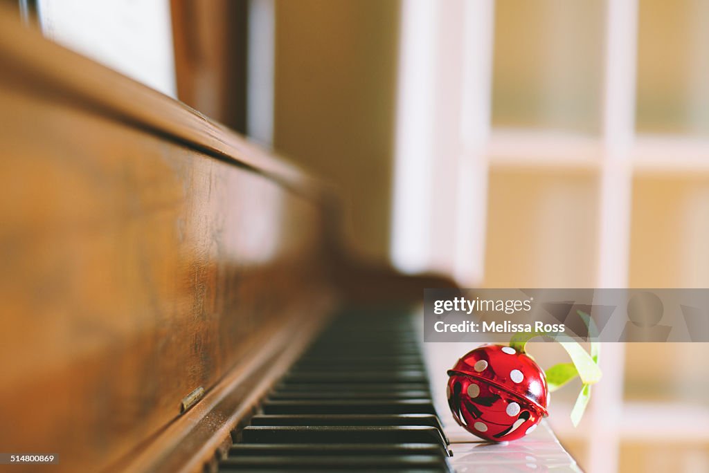 Red jingle bell with polka dots on piano keyboard