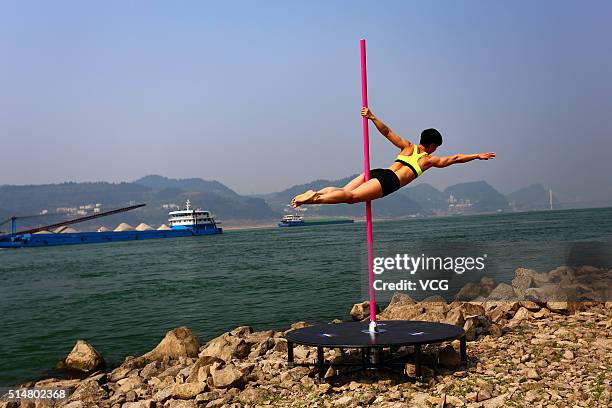 Pole dancer performs by the riverside of Yangtze River on March 11, 2016 in Yichang, Hubei Province of China. It's said that the performance comes...