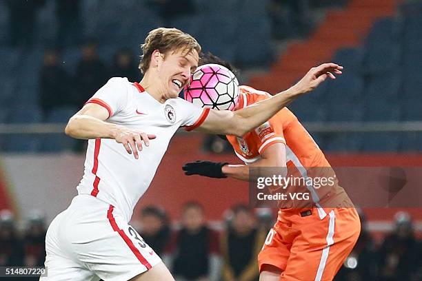 Michael Thwaite of Liaoning Whowin jumps to head the ball during the Chinese Football Association Super League match between Shandong Luneng and...