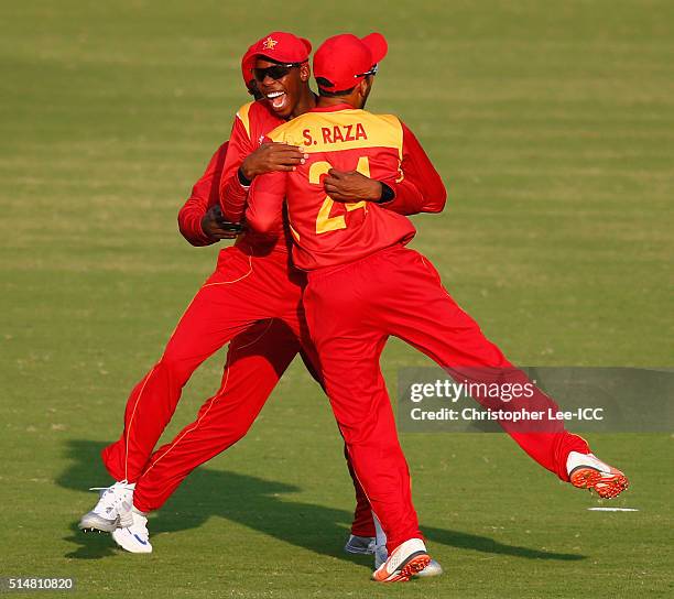 Sikandar Raza of Zimbabwe is congratulated by Wellington Masakadza after taking the catch of Kyle Coetzer of Scotland during the ICC Twenty20 World...