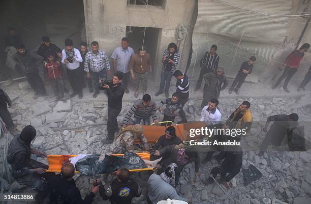 Syrians carry a wounded woman from a wreckage of a building after war crafts belonging to the Russian army carried out airstrikes on opposition...