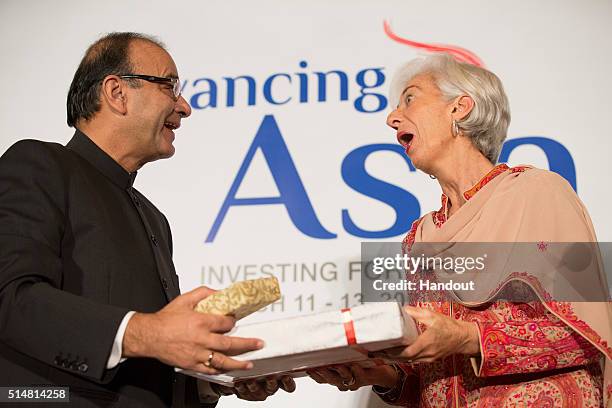 In this handout photo provided by the International Monetary Fund, International Monetary Fund Managing Director Christine Lagarde exchange gifts...