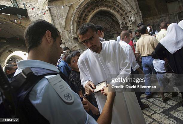 Israeli police check a Palestinian man's identity documents on his way to prayers at al-Aqsa mosque October 15, 2004 in Jerusalem's Old City. Some...