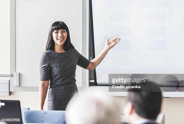 businesswoman giving a presentation - female lecturer stock pictures, royalty-free photos & images