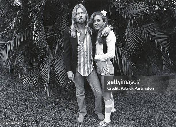 Portrait of American musician Gregg Allman and his bride, Julie Bidas, as they pose in the back yard of the Palm Beach Institute, West Palm Beach,...