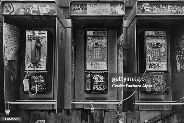 Graffiti covered broken pay phones in New York City, USA, December 1981.