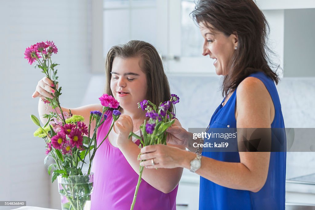 Mädchen mit down-Syndrom und Mutter arrangieren Blumen