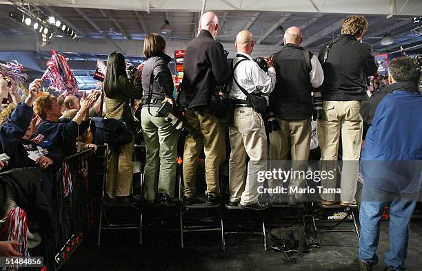 Photographers stand on chairs as they await the arrival of U.S. President George W. Bush at a Victory 2004 rally at the Experimental Aircraft...