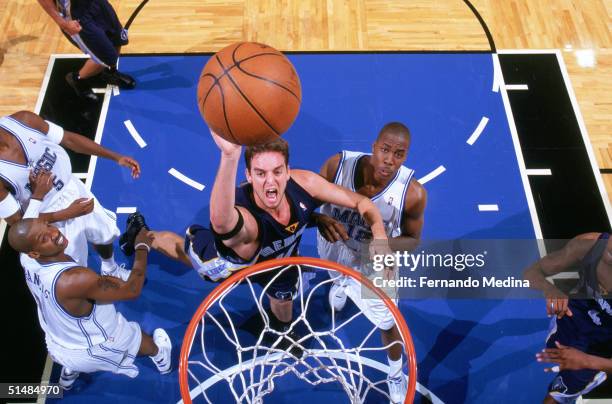 Pau Gasol of the Memphis Grizzles shoots while being defended by Dwight Howard of the Orlando Magic during the game at the TD Waterhouse Centre on...