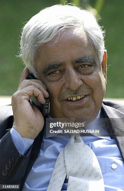 Chief Minister of the Indian state of Jammu and Kashmir, Mufti Mohammad Sayeed, speaks on a cellular telephone in the grounds of his residence in...