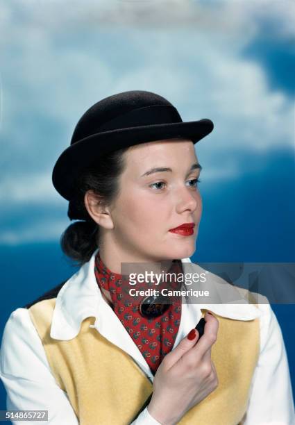 Portrait teen girl wearing equestrian outfit derby hat holding riding crop, Los Angeles, California, 1949.