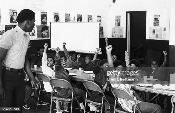 Teacher leads his students with the black power salute and slogans at a Black Panther liberation school.