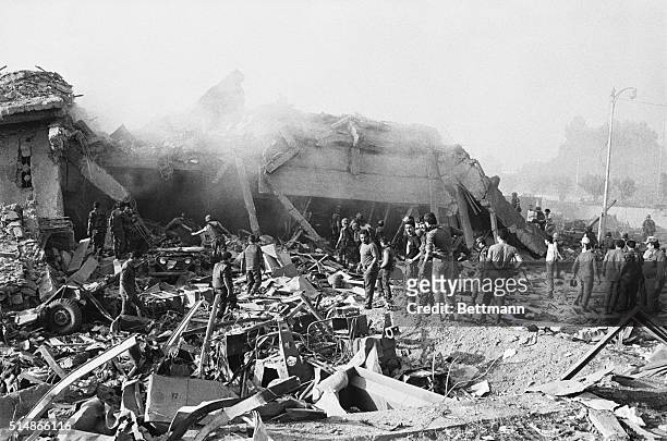 Workers sift through the rubble of a US marine barracks in Beirut, Lebanon which collapsed after a truck filled with explosives crashed through a...
