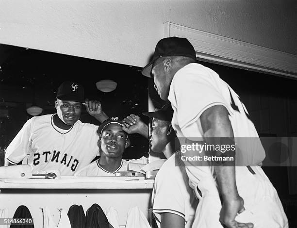 Outfielder Monte Irvin and infielder Hank Thompson try on their new Giants uniforms in a locker room at Polo Grounds in New York for a game against...