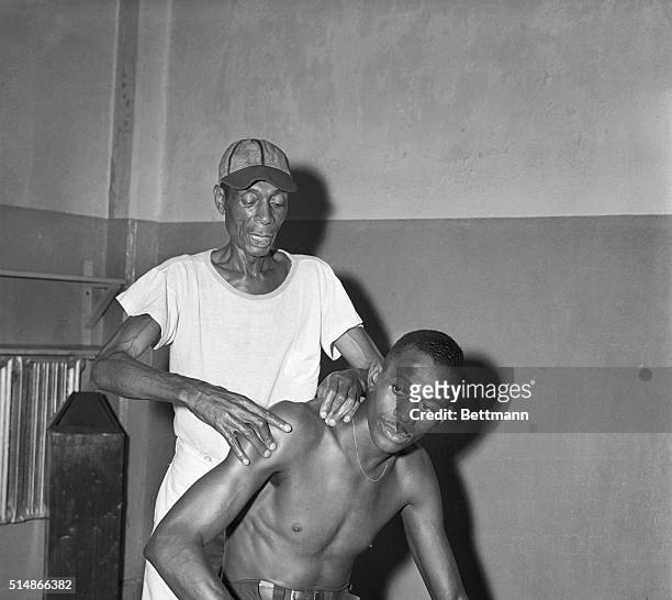 Kansas City Monarchs trainer Frank Floyd gives a shoulder rub to pitcher Satchel Paige, before a game against the New York Cuban Stars in Yankee...
