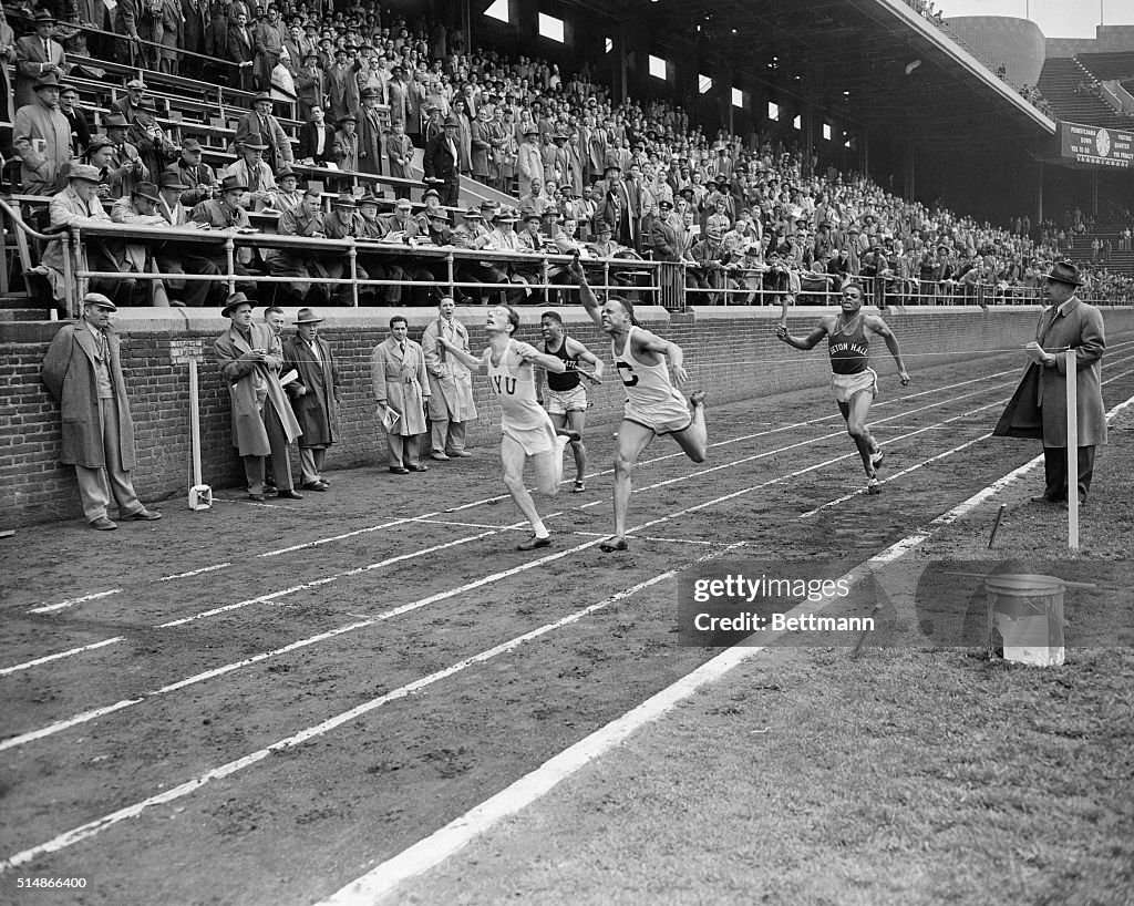 Runners Crossing Finish Line in College Relay Championship