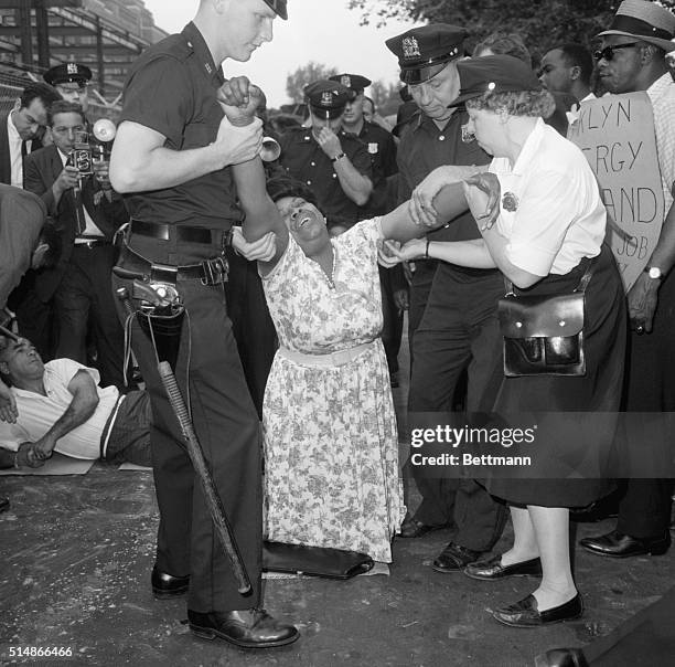 New York City police carry a sit-down demonstrator from the entrance to the construction site of the Downstate Medical Center to a patrol wagon, at...