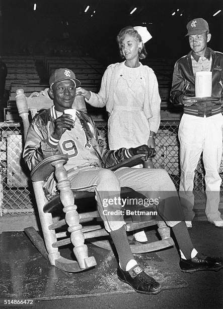 Hall of Fame pitcher Satchel Paige watches a game between the Kansas City A's and the Washington Senators from a rocking chair near the A's bullpen....