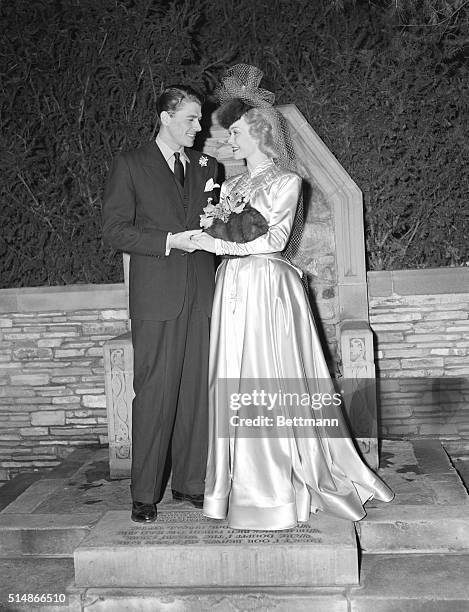 Glendale, CA: Jane Wyman and Ronald Reagan, young film stars, standing in front of the traditional "Wishing Chair" at the Wee Kirk O'Heather,...