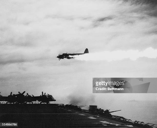 Japanese Kamikaze plane misses hitting a U.S. Aircraft carrier after being damaged by the carrier's guns.