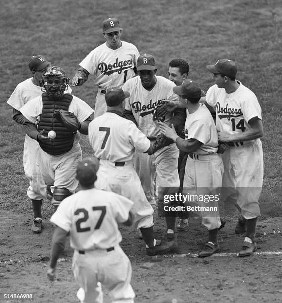 Teammates mob Brooklyn Dodgers' starting pitcher Joe Black after he led his team to a win over the New York Yankees in the opening game of the 1952...