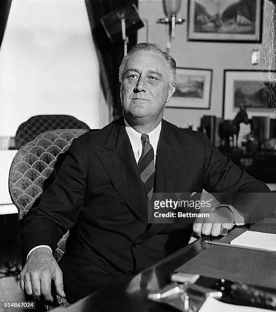 President Franklin Delano Roosevelt sitting at his desk in the Oval Office.