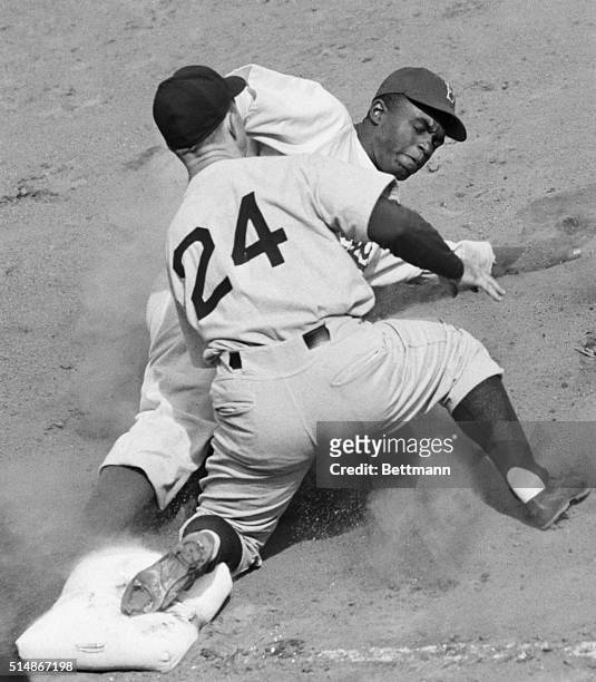 In a pre-season game at Ebbets Field, New York Yankee third baseman Bill Johnson tags out Jackie Robinson of the Brooklyn Dodgers as Robinson tried...