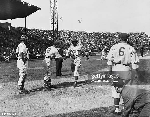 Jackie Robinson crosses homeplate after hitting a three-run home run, on Opening Day of the 1946 Montreal Royals season. Today Robinson becomes the...
