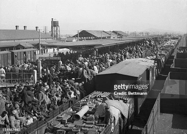 Pengpu, China: Nationalist ammunition train passes freight train jammed with civilian refugees attempting to leave Pengpu area, Dec. 4, as battle...