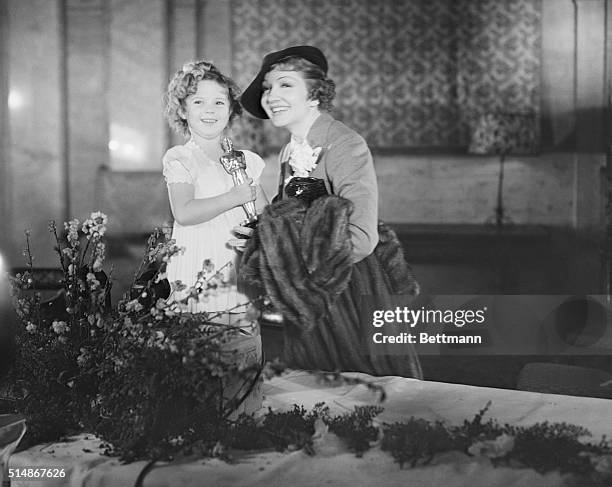 Los Angeles, CA: Shirley Temple, child star, and Claudette Colbert, film luminary, with their awards presented them by the Academy of Motion Picture...