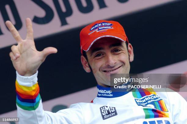 Italy's Paolo Bettini celebrates as he wears the World Champion jersey on the podium of the "Giro di Lombardia", in Como 16 October 2004. Italian...