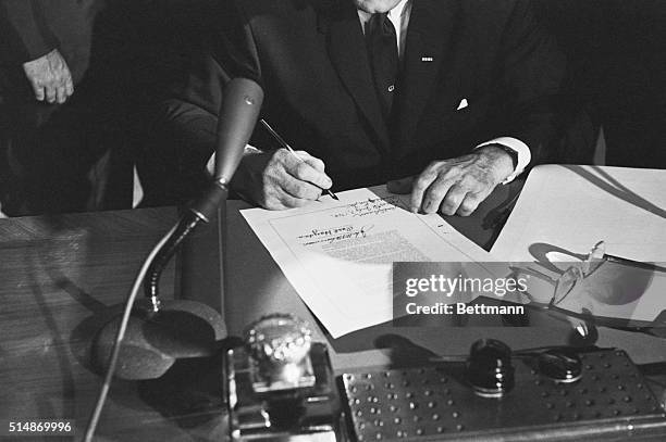 Washington, DC: The hands of President Lyndon Johnson rest on the signed Civil Rights bill after the Chief Executive signed the measure into law at...