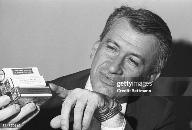 Washington, DC: Dr. Daniel Horn, director of National Clearing House for Smoking and Health, today holds three packages of cigarettes bearing new...