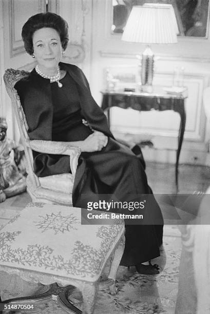 Paris, France: Sitting in her Paris home, the Duchess of Windsor wears Givenchy's long dress and cape ensemble of black satin. The Dutchess, who has...