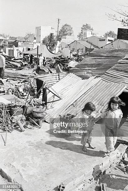 Hue, South Vietnam: Two little Vetnamese girls walk in the midst of the rubble Feb. 3 where once their homes stood prior to week-long savage street...