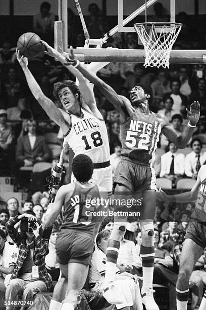 Boston, MA: Dave Cowens , of the Boston Celtics, grabs a rebound away from New Jersey Nets' George Johnson during second quarter action at Boston...