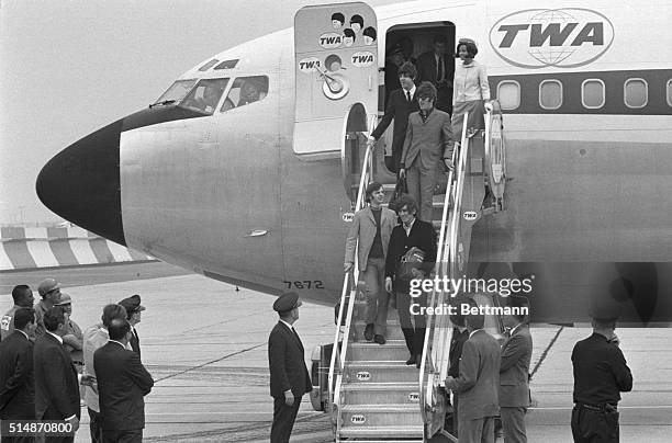 New York, NY: The Beatles : Paul Mcartney, John Lennon, Ringo Starr, and George Harrison, alight from their plane at a secluded part of Kennedy...