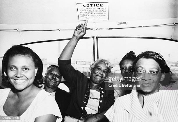 Passenger points to one of the segregation signs removed from all Dallas Transit Company buses, following a Supreme Court ruling banning segregation...