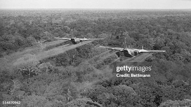Vietnam: Two C-123's of the 12th Air Commando Squadron fly low over heavy jungle in War Zone C spraying the canopy with defoliation Liquid. The spray...